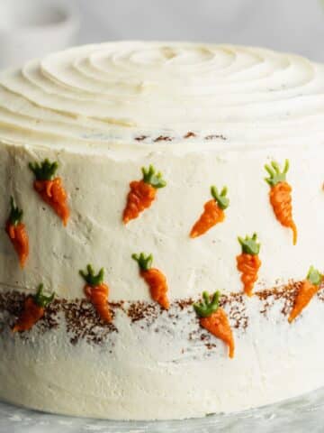 carrot cake with piped carrot decorations.