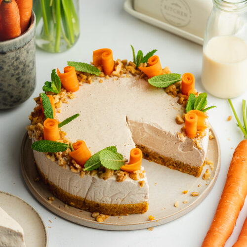 carrot cake cheesecake with candied carrots and mint leaves on top.