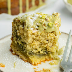 a slice of pistachio crumb cake with pistachio butter center and a biteful taken from it.