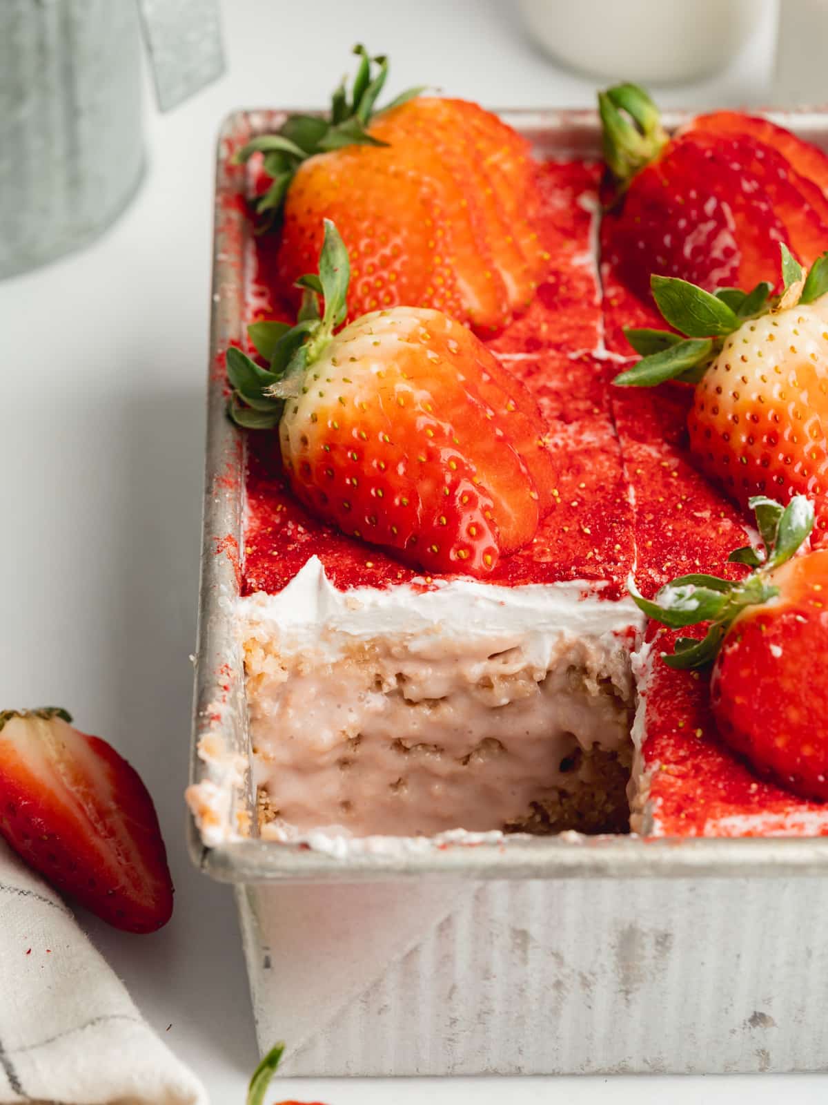 strawberry tres leches with a slice taken showing the moist texture.