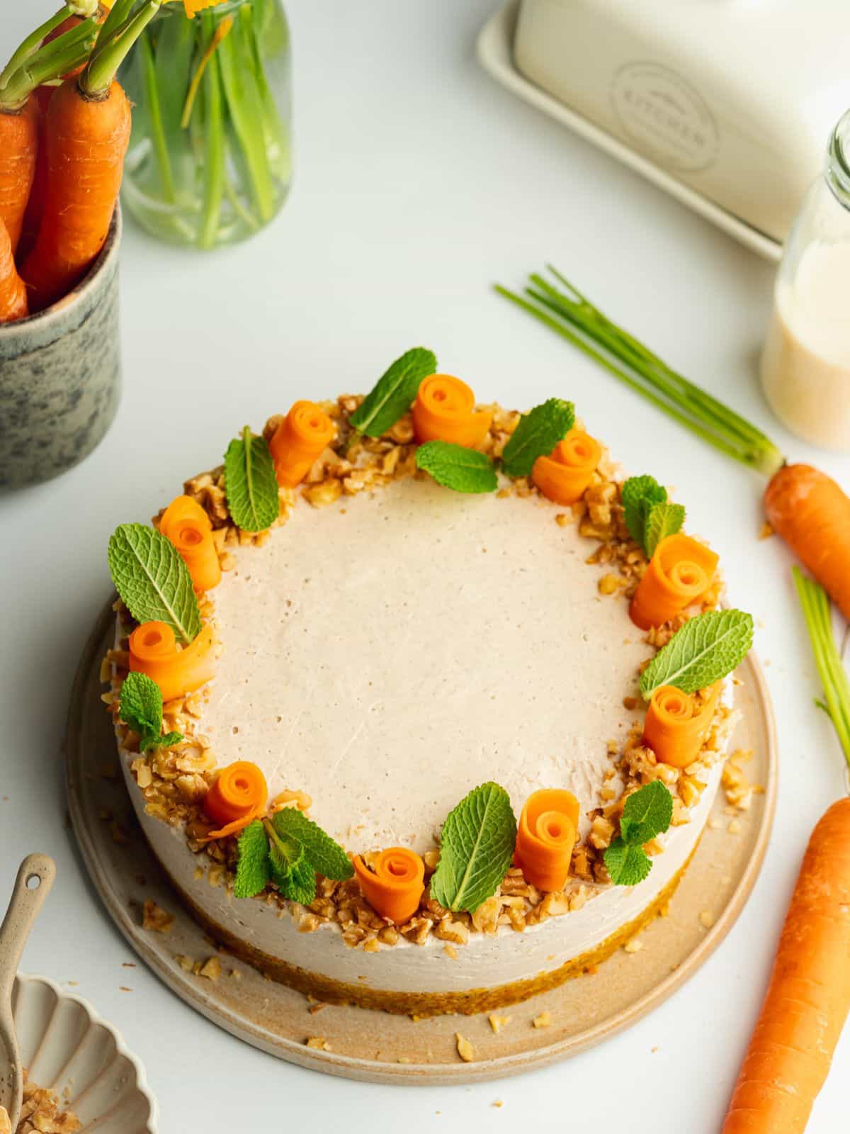 no bake cheesecake decorated with candied carrots, chopped nuts and mint leaves.