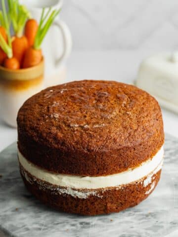 two layers of carrot cake with a layer of frosting between the layers.
