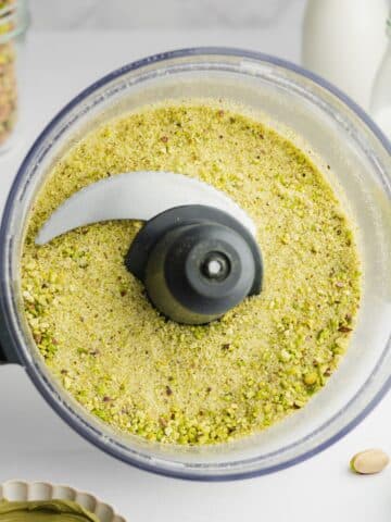 pistachios and sugar ground together in a food processor jug.