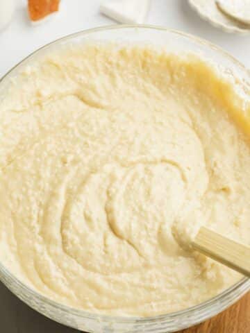 coconut cake batter folded in a large clear bowl.