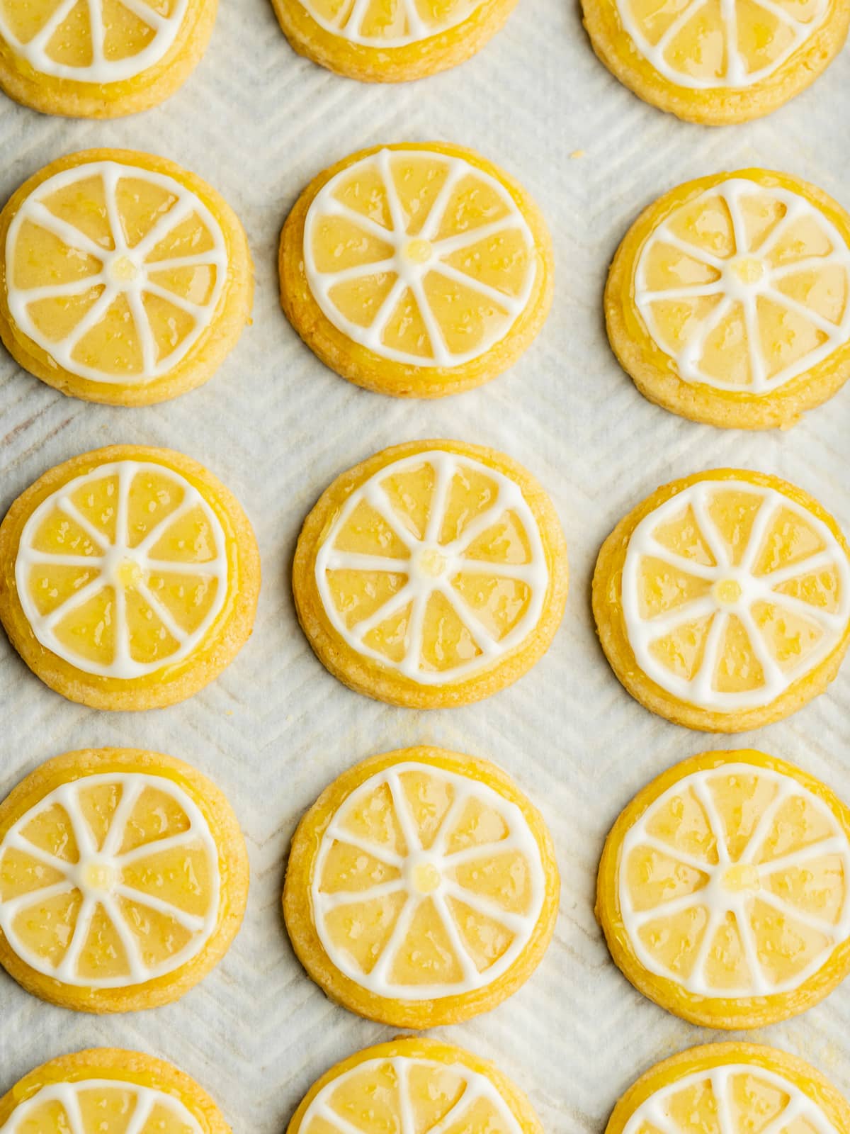 a tray lined with lemon cookies with lemon slice designs iced on them.