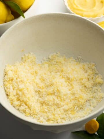 sugar with lemon zest rubbed into it in a large ceramic bowl.
