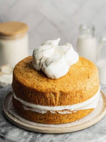 coconut sandwich cake with dollops of whipped coconut cream on top.