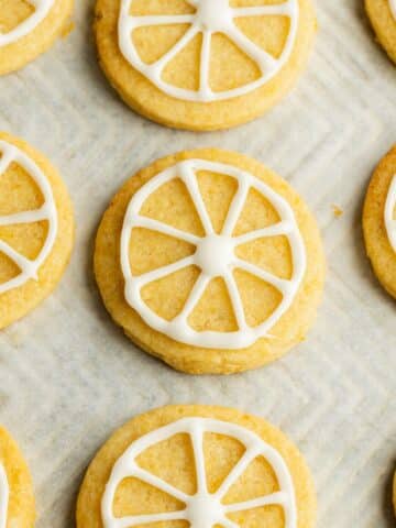 baked lemon sugar cookies with a royal icing outline of a lemon slice.