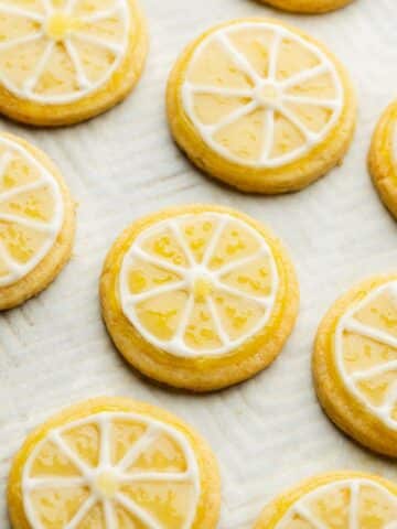 lemon slice cookies on a sheet decorated with lemon curd icing to resemble slices of lemon.