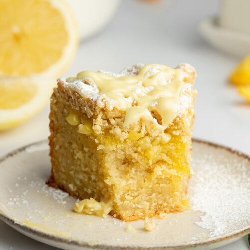 a slice of lemon crumb cake with a bite taken from it and gooey lemon curd oozing out.