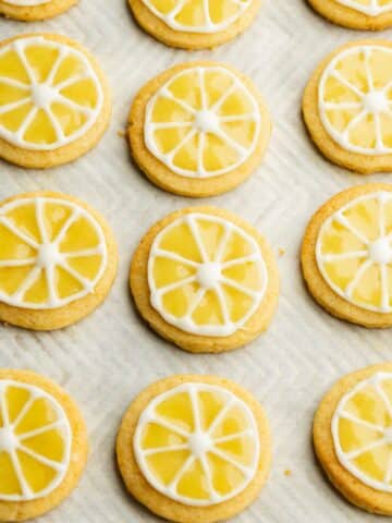 lemon cookies on a baking sheet flooded with lemon curd icing.