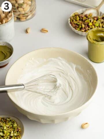 whipped coconut cream in a bowl with a whisk.