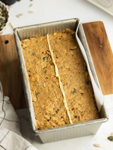 brown bread in a lined pan with a strip of butter down the center.