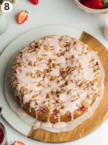 coffee cake drizzled with strawberry glaze on a cutting board.