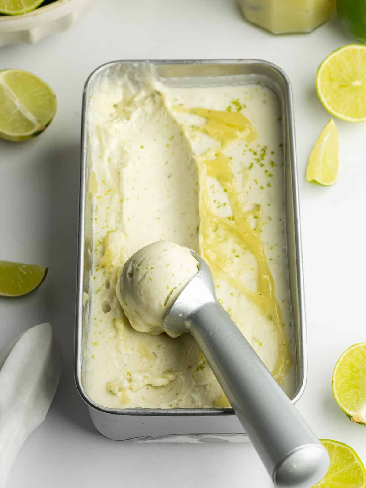 a loaf pan with lime ice cream and swirls of lime curd.