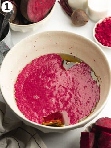 a large ceramic bowl with beetroot puree and other wet ingredients for cake before mixing.