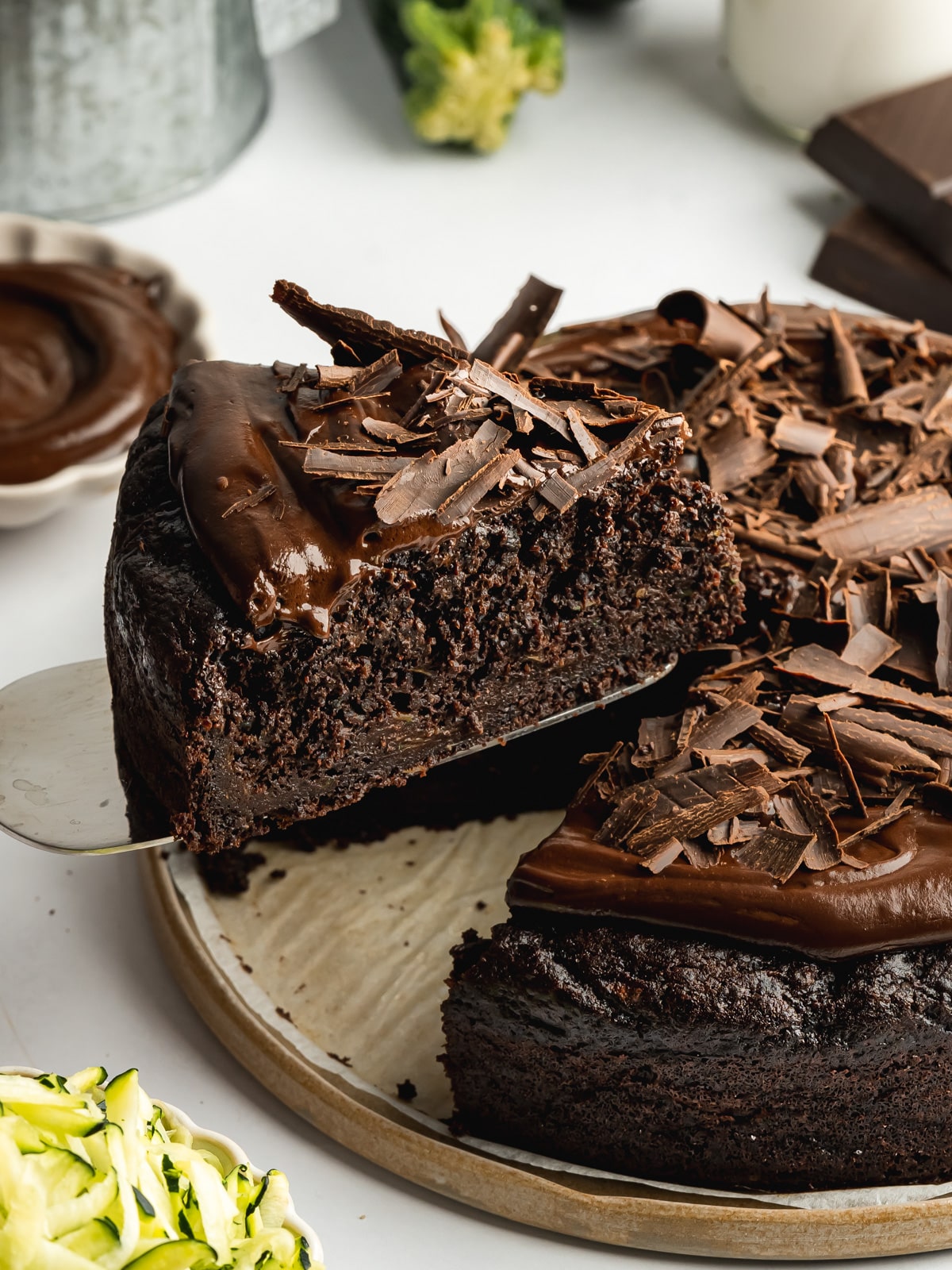 a slice of moist chocolate courgette cake being lifted away on a cake slice.