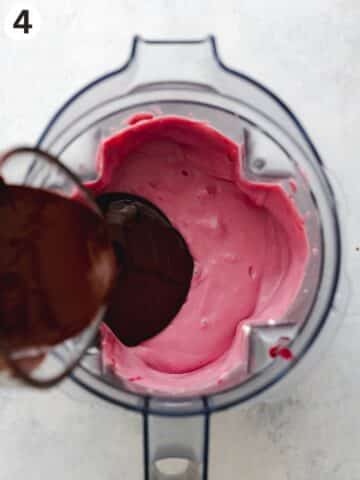 pouring melted chocolate into a blender jug with cherry cheesecake filling.