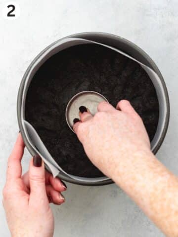 pressing oreo cookie crust into a lined cake pan.