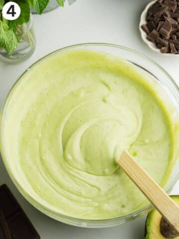 mint ice cream mixture in a bowl with a rubber spatula.
