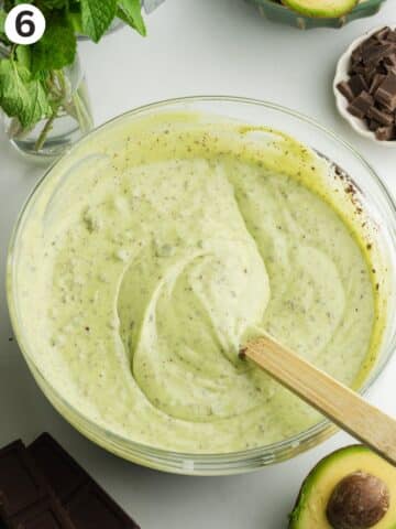 mint chocolate chip ice cream mixture in a large mixing bowl with a rubber spatula.