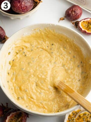 passion fruit cake batter in a mixing bowl with a rubber spatula.