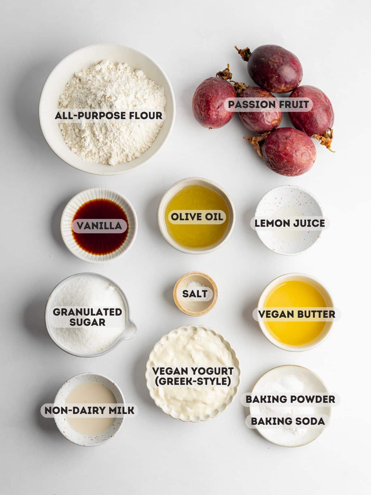 ingredients for passion fruit cake measured out in bowls on a gray surface.