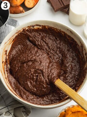 thick sweet potato chocolate cake batter in a mixing bowl with a rubber spatula.