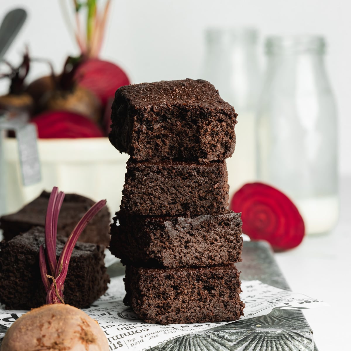 a stack of beetroot brownies with a bite taken out of the top one showing the moist fudgy consistency.