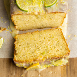 a slice of lemon zucchini bread with lime icing on a wooden cutting board.