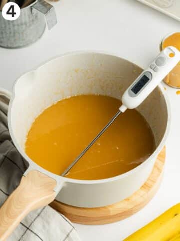 toffee sauce with a candy thermometer in a saucepan.