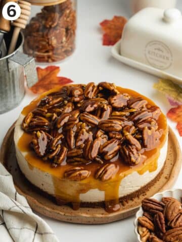 no bake cheesecake with caramel pecan topping on a brown ceramic plate.
