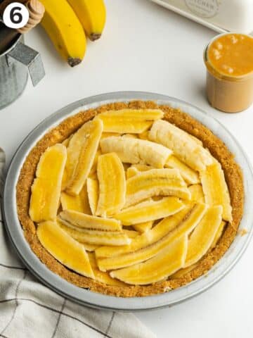 banana slices arranged o top of toffee filling in a pie.