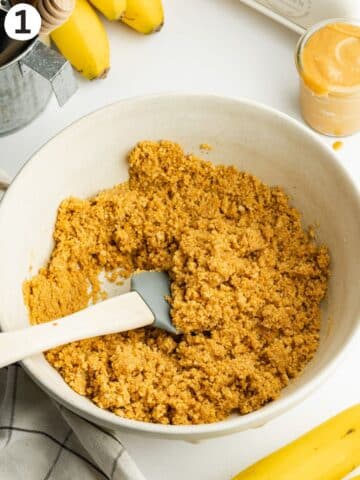 cookie crumbs and melted butter resembling wet sand in a mixing bowl.