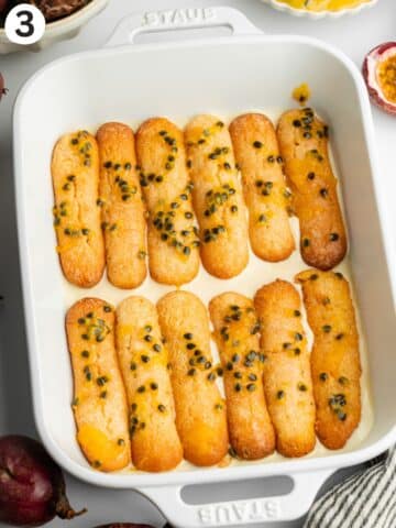 ladyfingers dipped in passion fruit soak arranged in a staub dish.