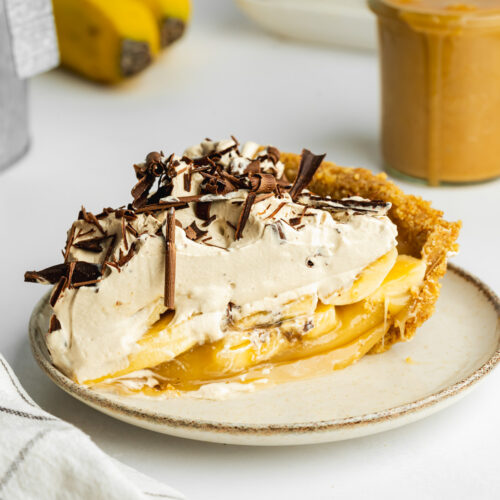 a slice of banoffee pie with espresso coconut cream on a ceramic plate.