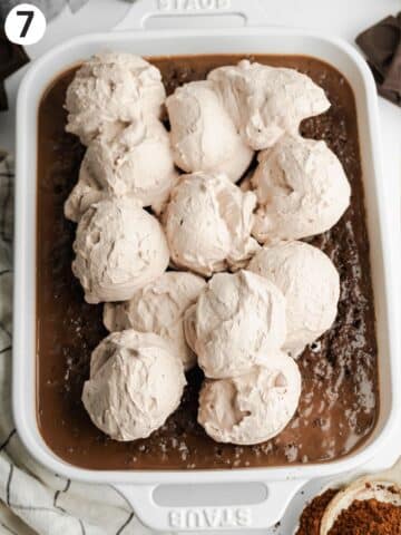 chocolate tres leches with scoops of chocolate cream on top.