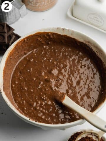 chocolate cake batter in a large bowl with a spatula.