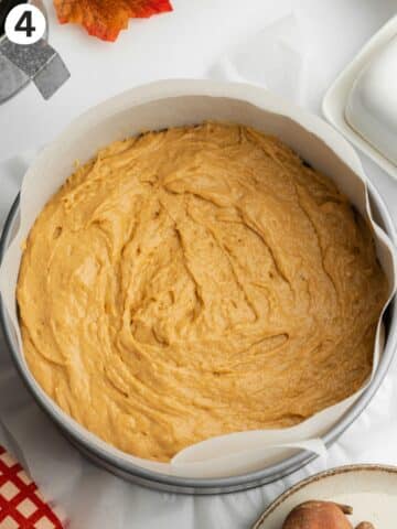 a lined cake pan with sweet potato cake batter before being topped with pecan streusel.