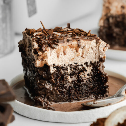 a slice of chocolate tres leches in a pool of chocolate milk.