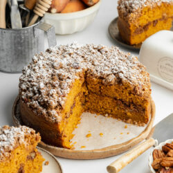 a sweet potato coffee cake with a few slices cut from it showing the fluffy crumb.