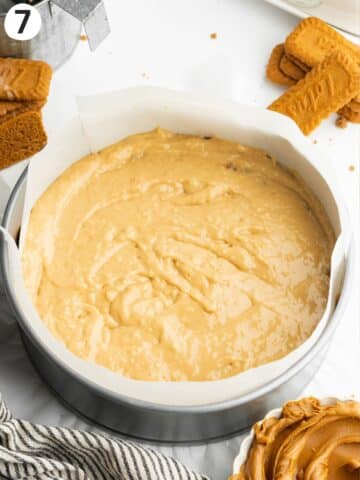 biscoff cake batter in a parchment-lined cake pan before baking.