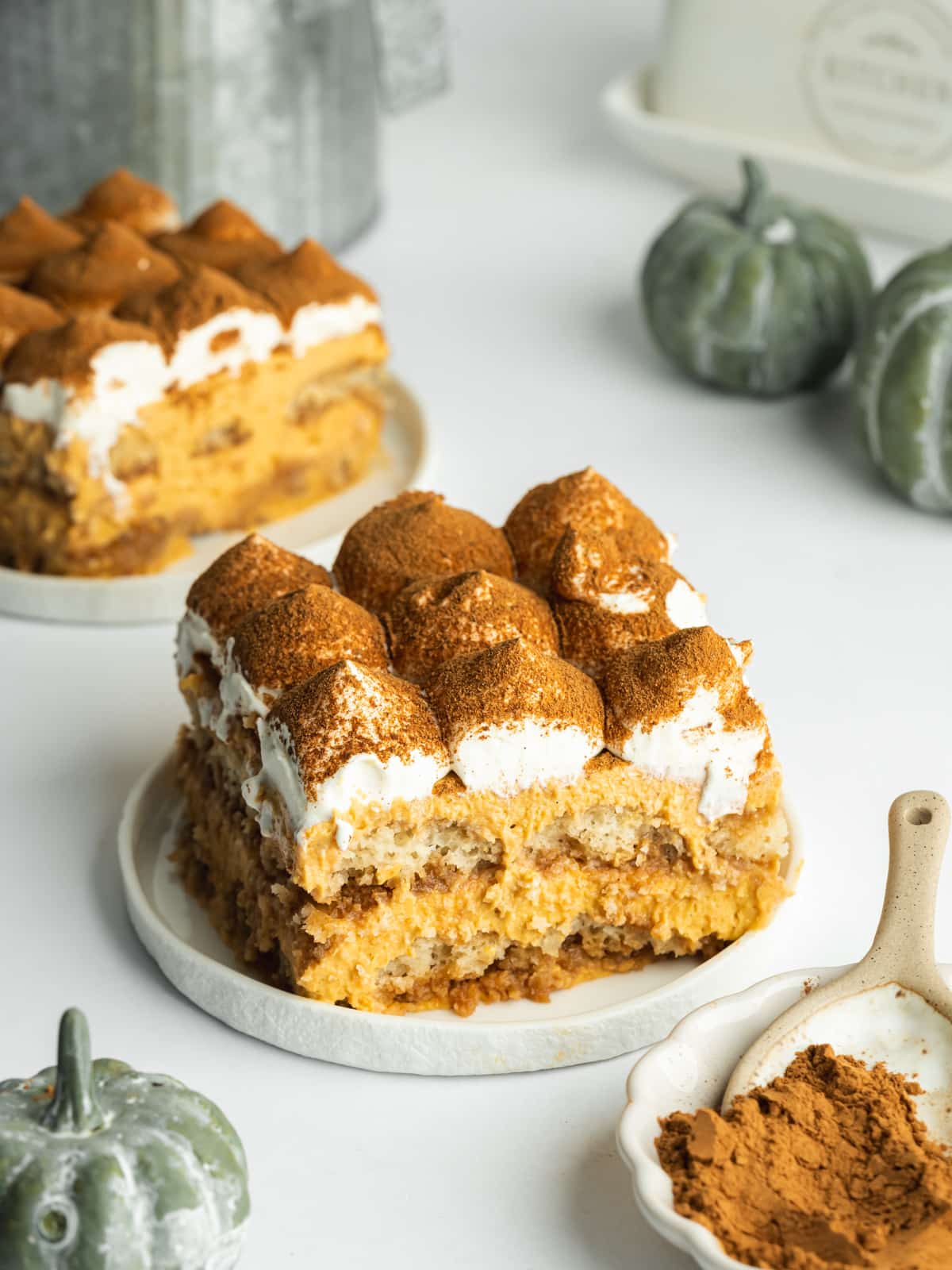 a slice of pumpkin tiramisu on a small white ceramic plate.