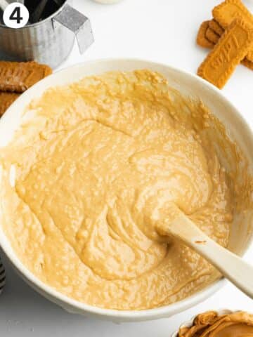 biscoff cake batter in a ceramic bowl with a rubber spatula.