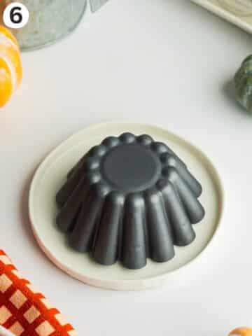 a small flan mold turned upside down on a small plate.