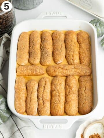 second layer of coffee soaked ladyfingers on pumpkin tiramisu filling.