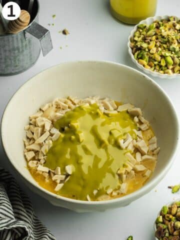 a large ceramic bowl with pistachio fudge ingredients before melting.