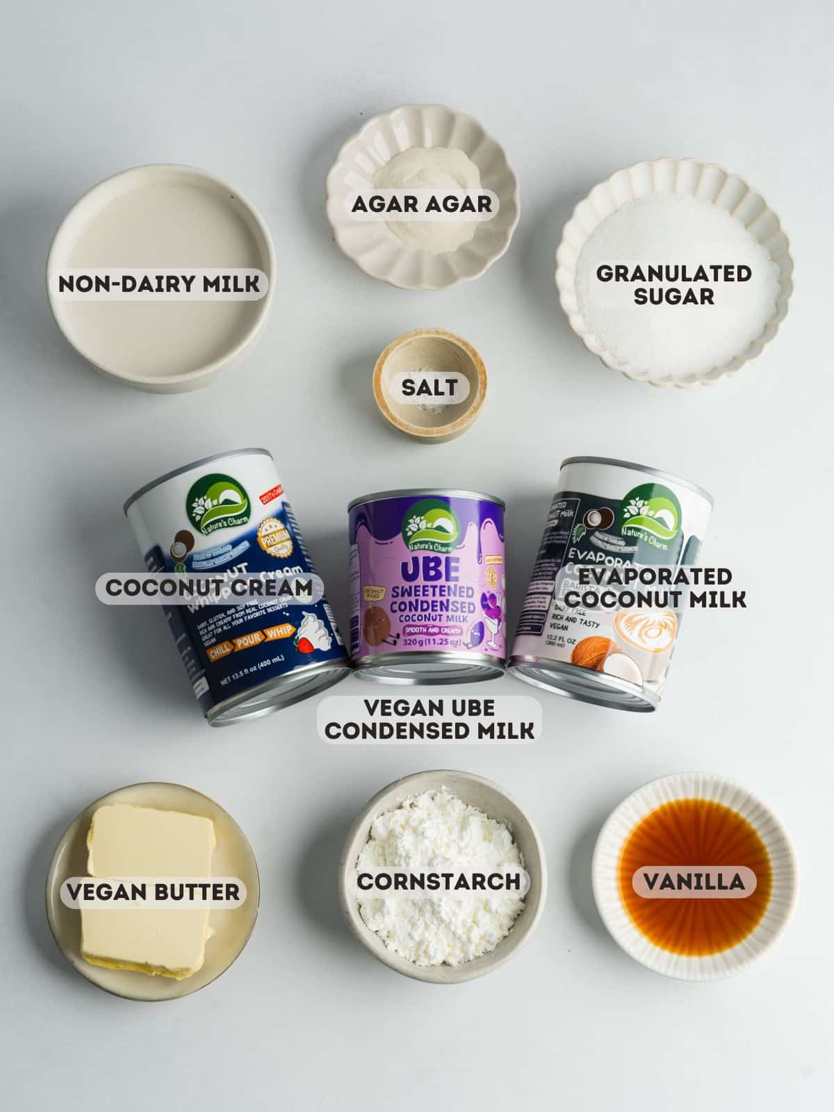 ingredients for ube flan measured out in bowls on a gray surface.