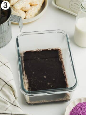 espresso soak with ube condensed milk in a shallow clear container.