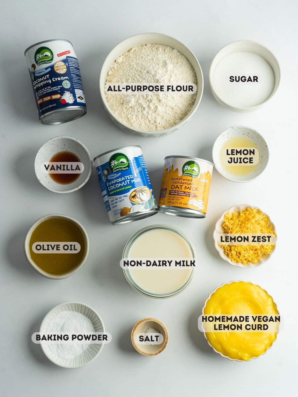 ingredients for lemon tres leches measured out in bowls on a gray surface.